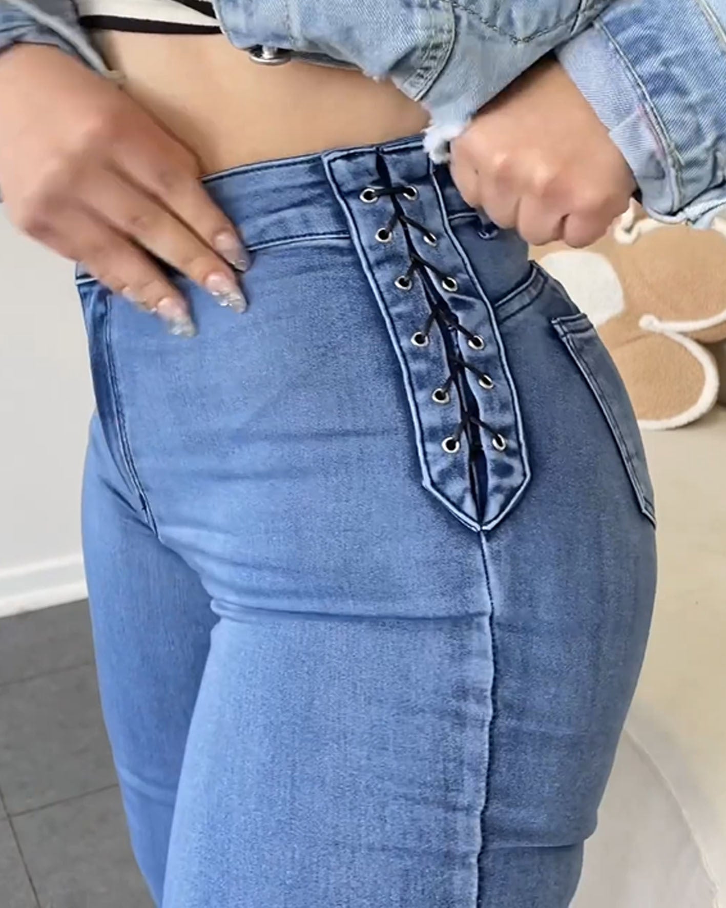 Jeans azul claro de cintura alta con amarre lateral y efecto moldeador - vista lateral